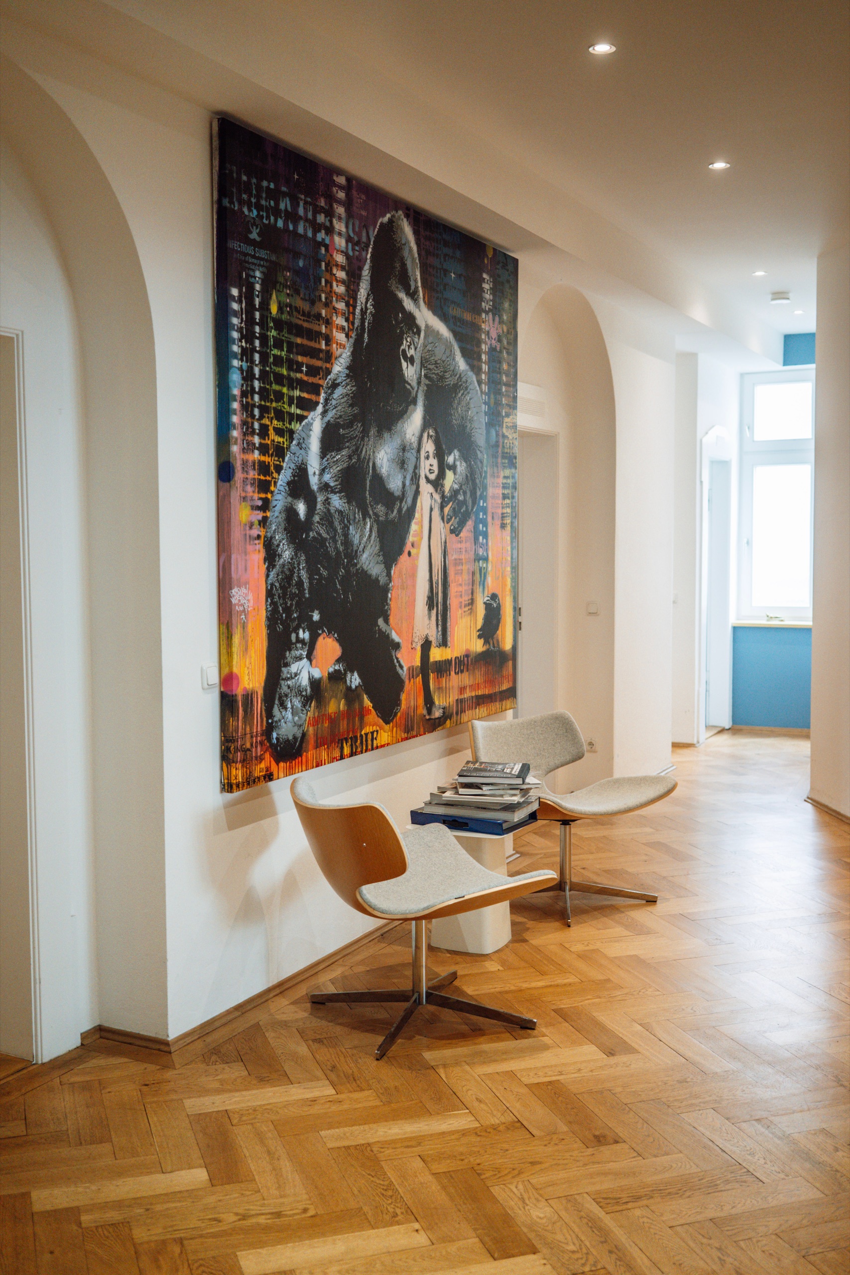 Hallway in the CNX office with a large painting and two armchairs