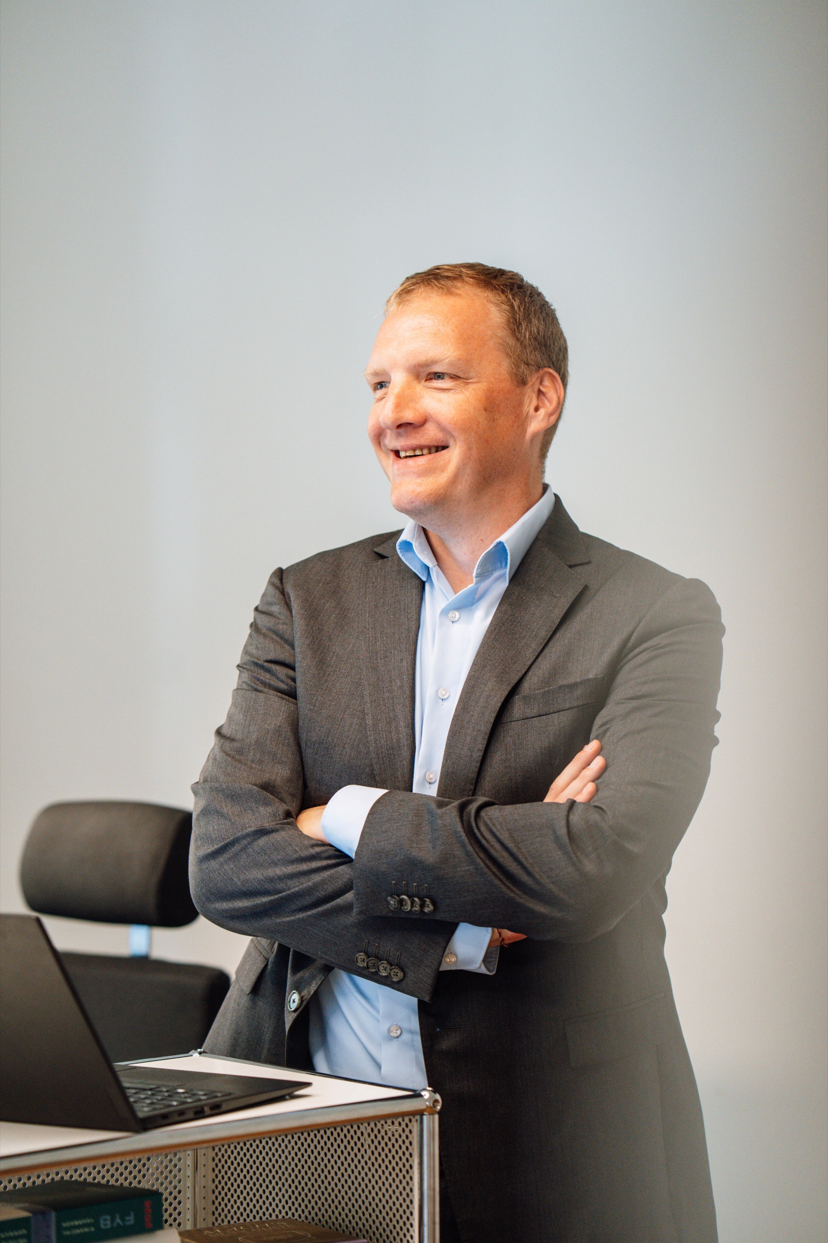 Dr. Willem Keijzer steht lächelnd mit verschränkten Armen im Büro