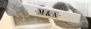 "M&A Berater" steht auf einem Ordner, den sich zwei Menschen überreichen