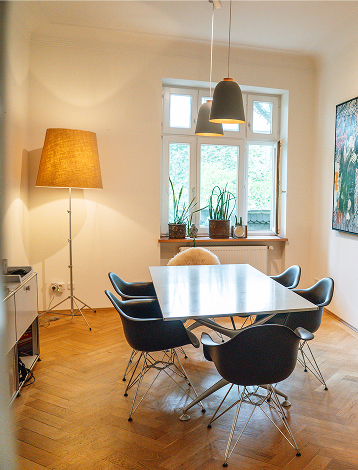 Meeting room in the CNX office with a conference table, floor lamp and window