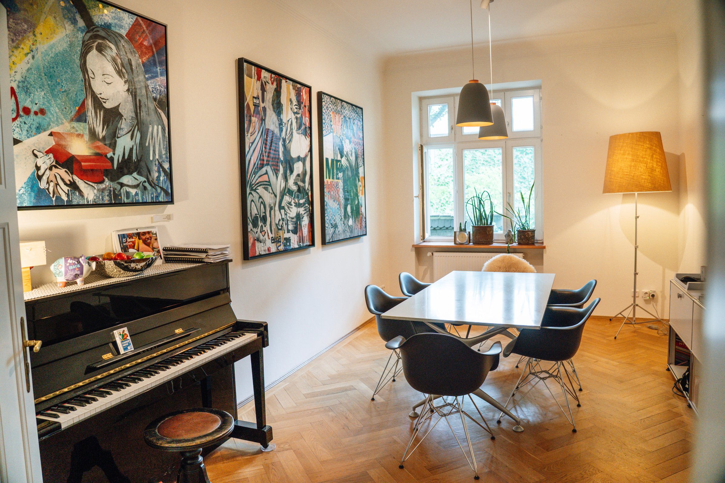 Meeting room in the CNX period-building office in Munich-Schwabing with a conference table, piano and art on the wall