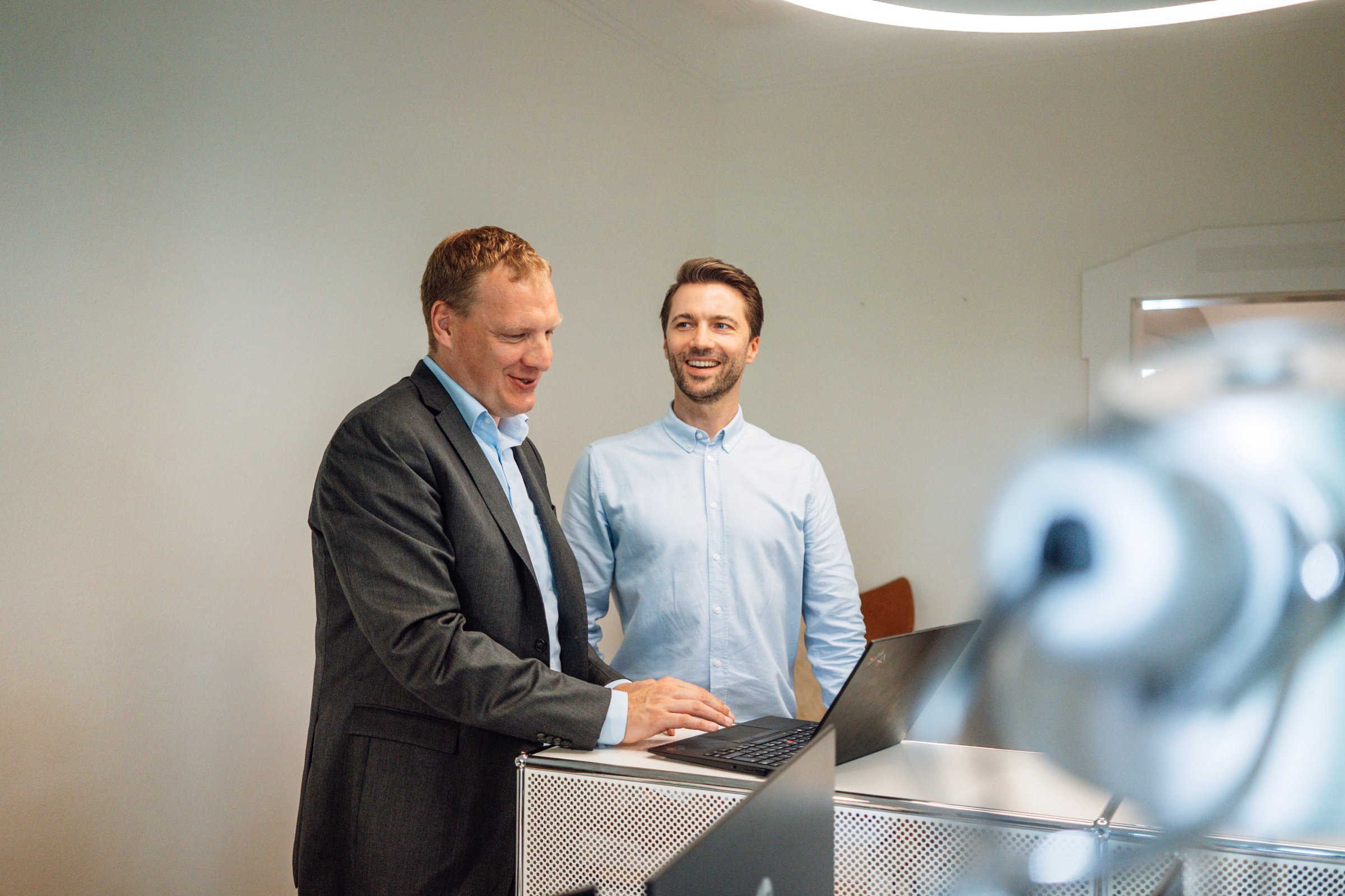 Dr Willem Keijzer and a colleague in conversation at a standing desk in the office