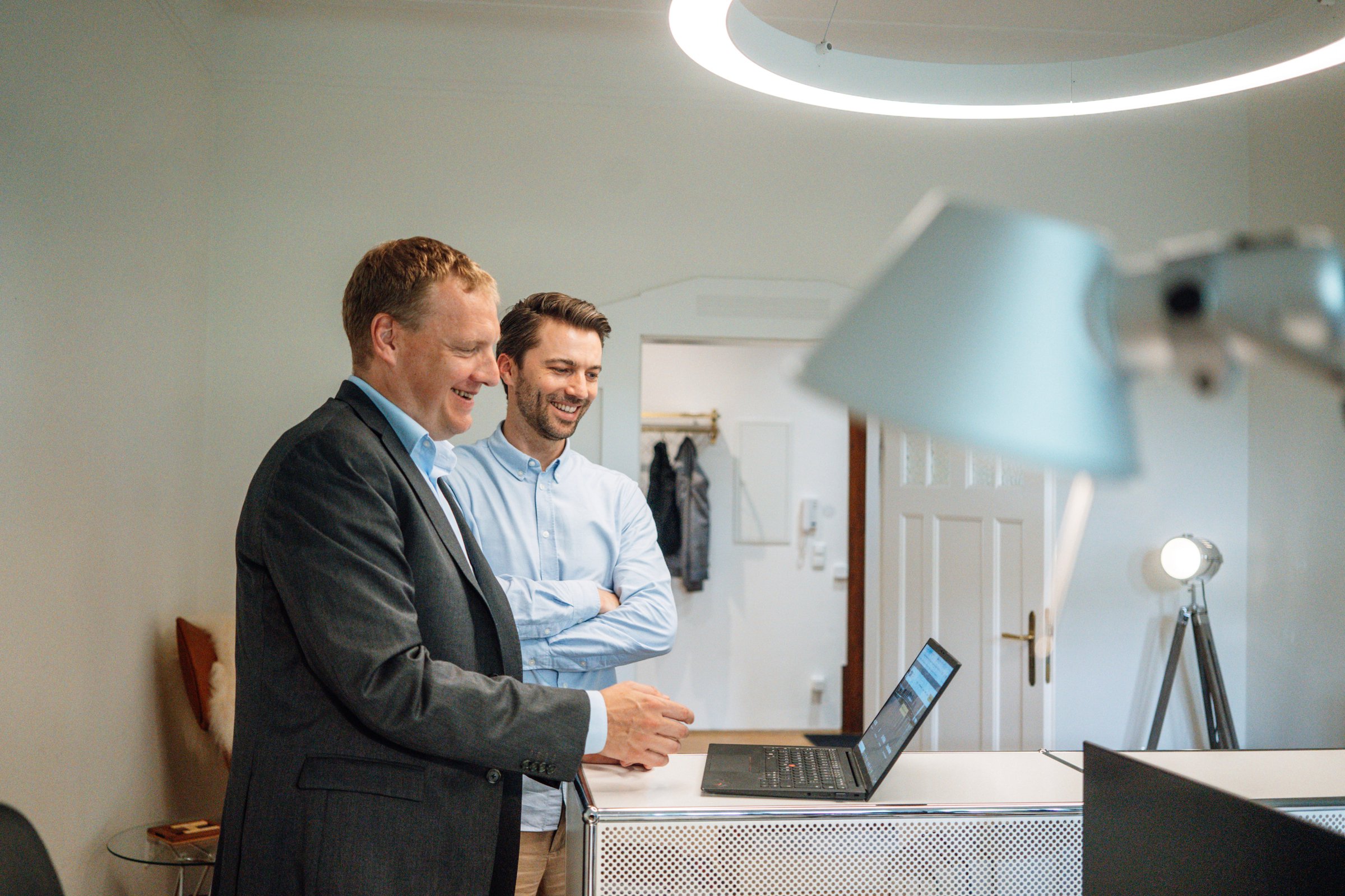 Dr Willem Keijzer and a colleague working together on a laptop at a standing desk in the office