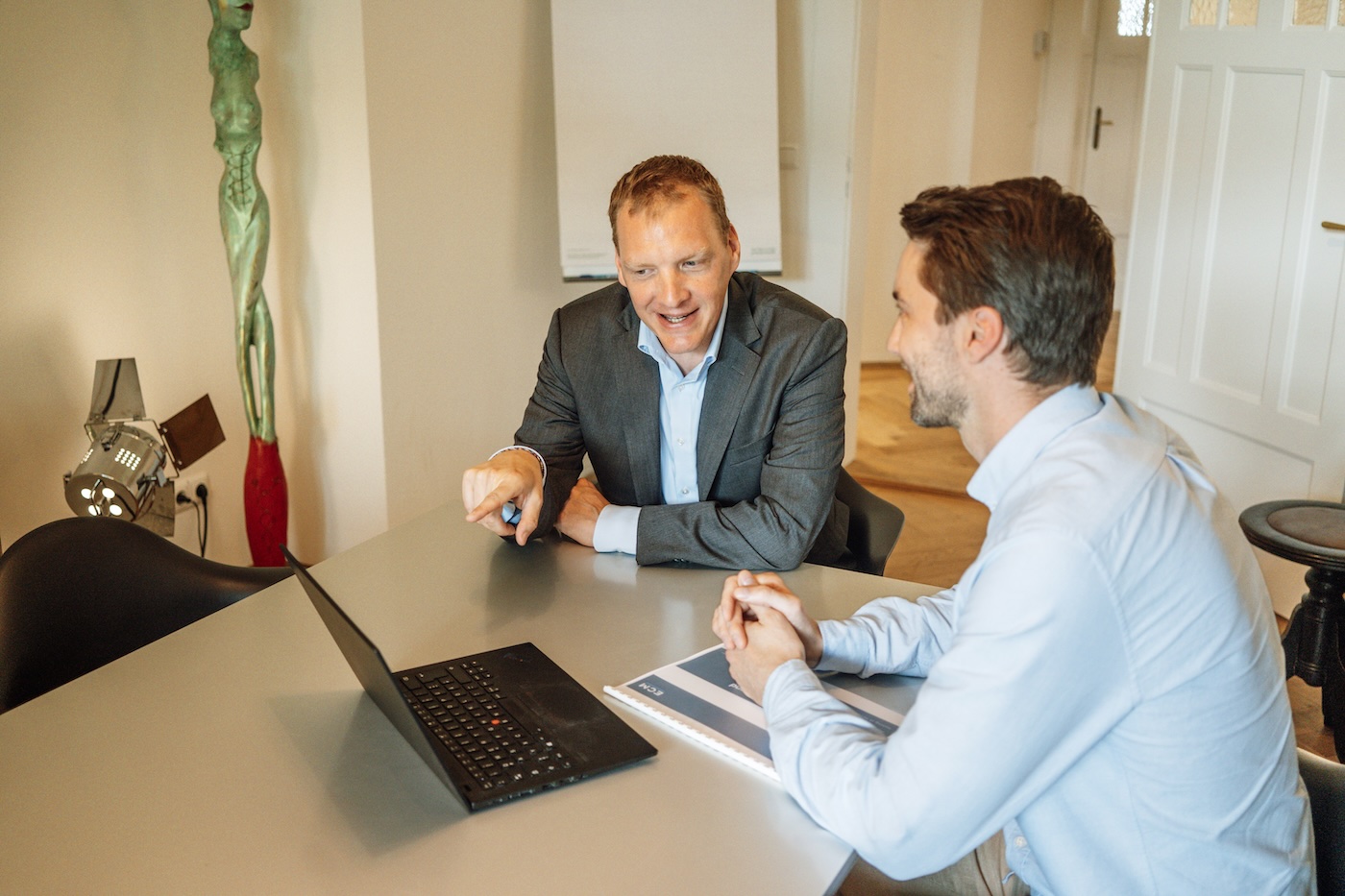 Dr. Willem Keijzer im Gespräch an einem Tisch mit Laptop und Unterlagen