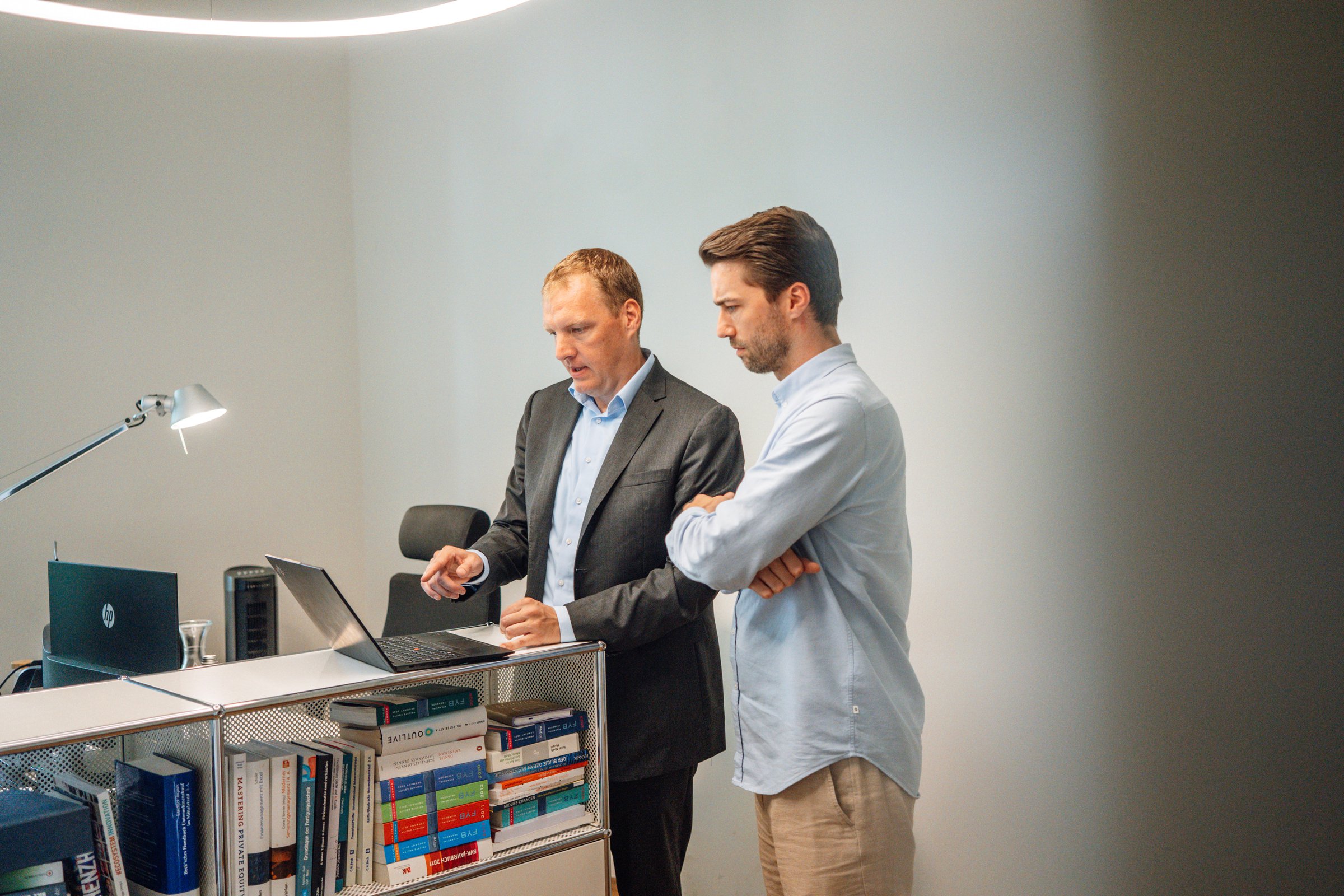 Dr Willem Keijzer discussing documents with a colleague at a standing desk