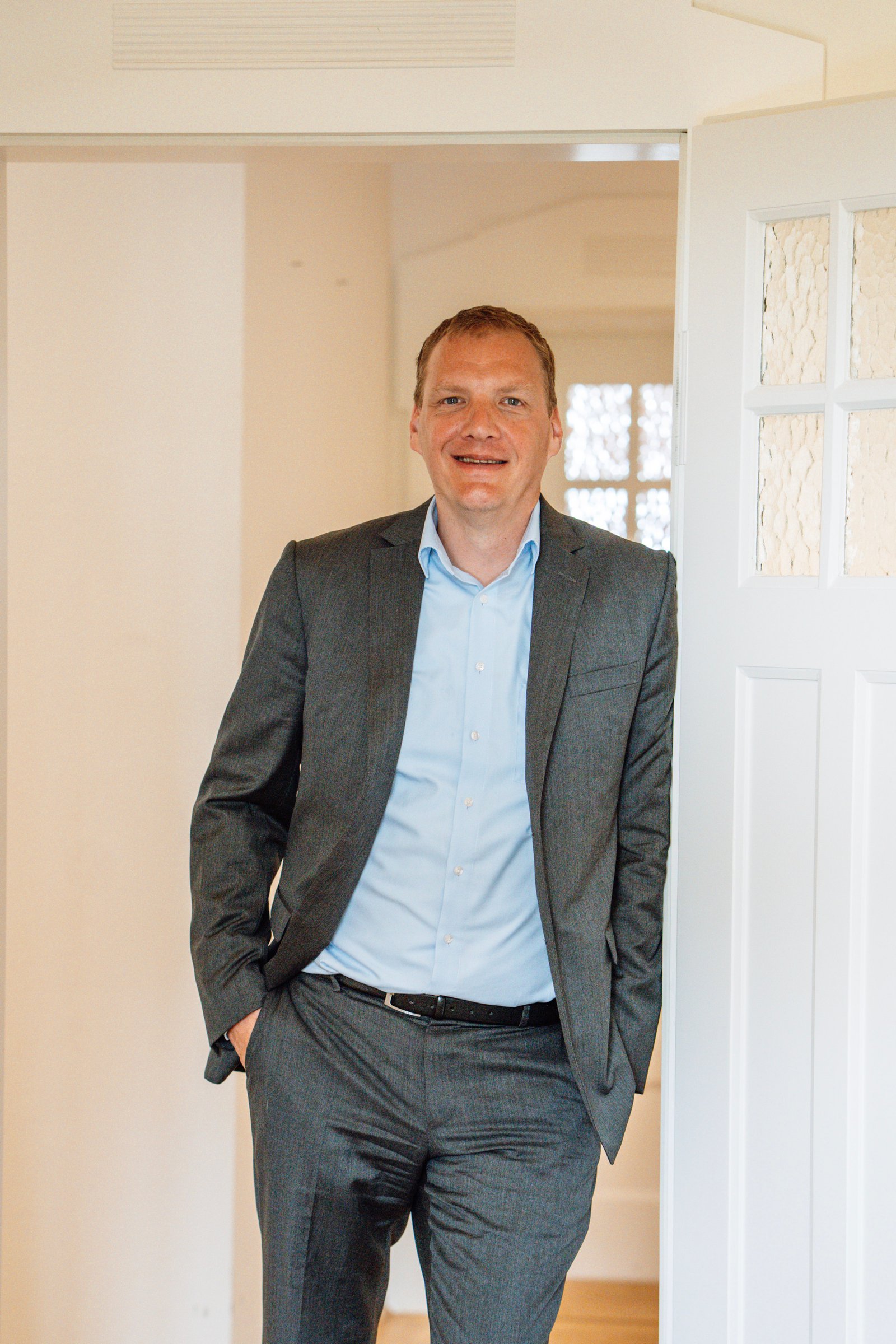 Dr Willem Keijzer, founder and Managing Partner of CNX Transaction Partners, leaning in a doorway and smiling